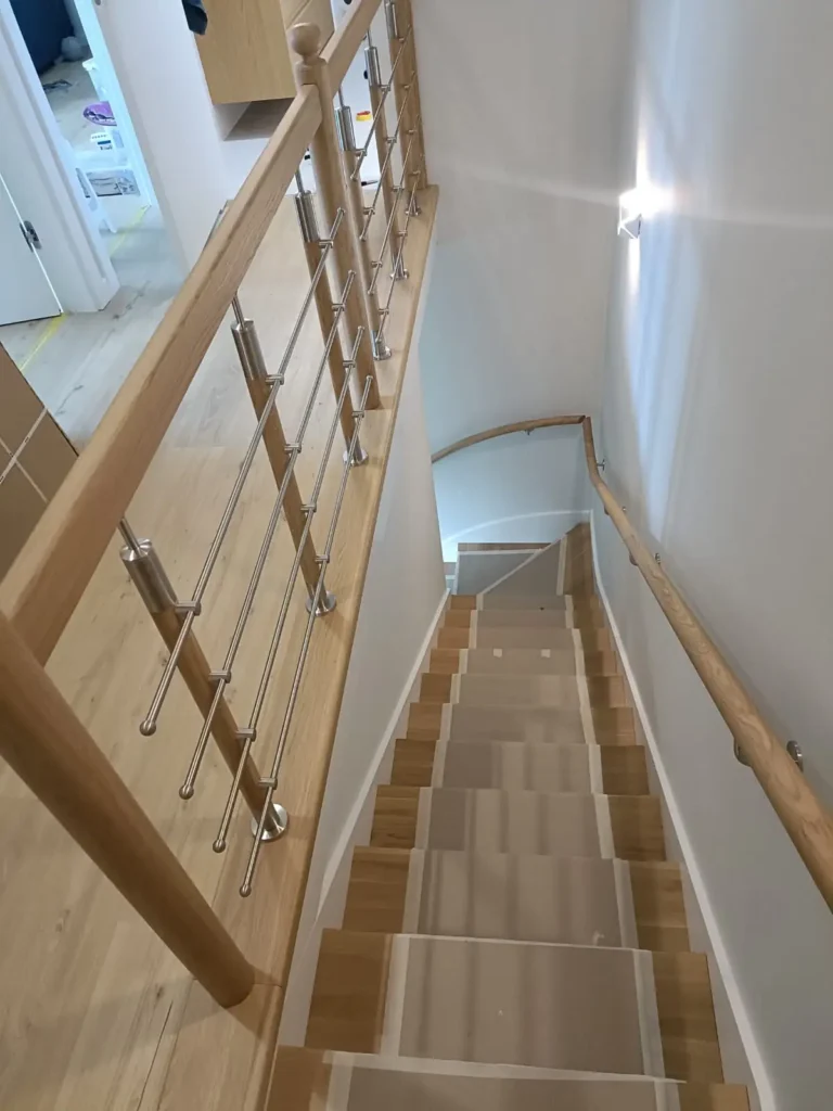 Drewniane schody z balustradą w wykończonym domu pod klucz w Liszkach pod Krakowem.