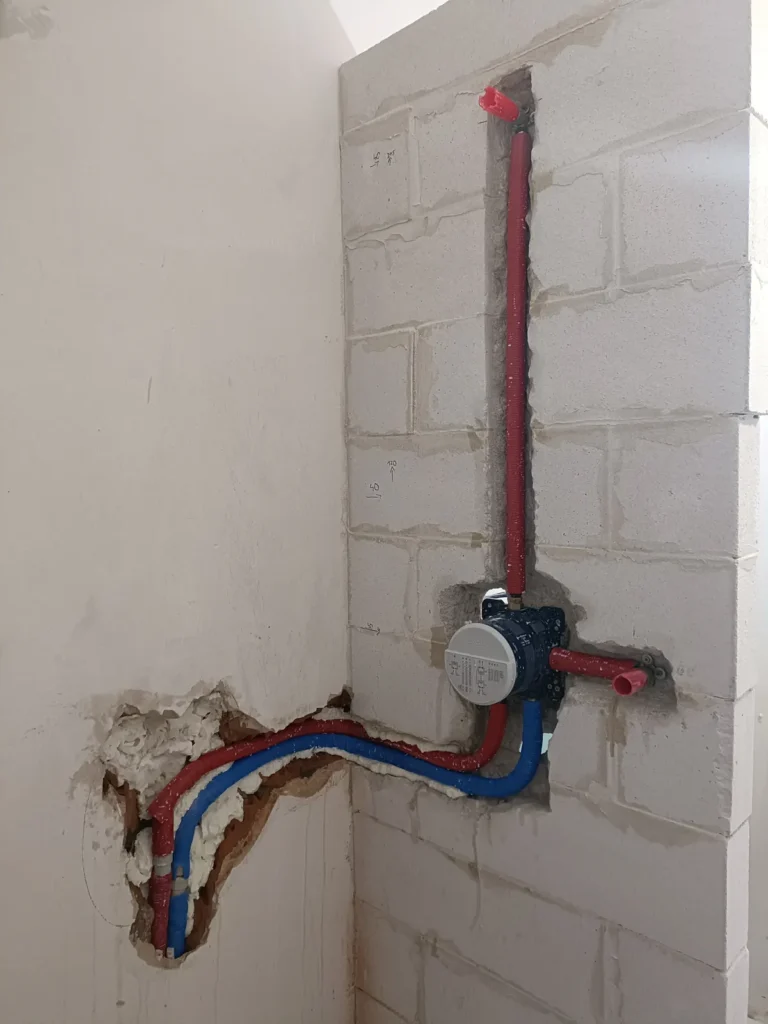 Podejścia wodne i podtynkowy element armatury podczas zmian instalacji hydraulicznej w wykańczanym domu w Liszkach pod Krakowem.